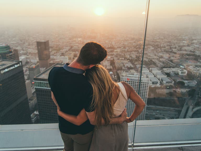 A couple watches the sunset at OUE Skyspace in Downtown LA